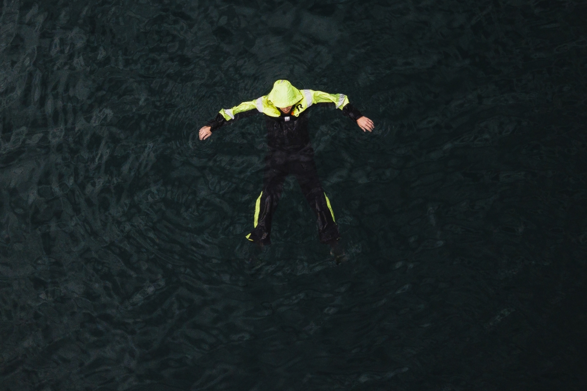 En person flyter i vannet iført flytedrkt fra Regatta